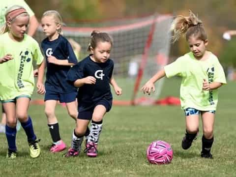 girls playing football on a field