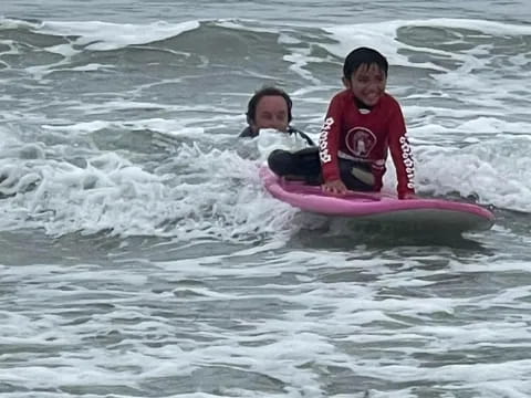 a couple of people ride surfboards