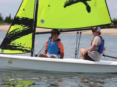 a couple of people in a sailboat on water