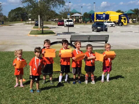 a group of kids in orange uniforms