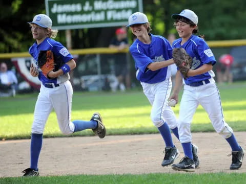 girls playing baseball on a field