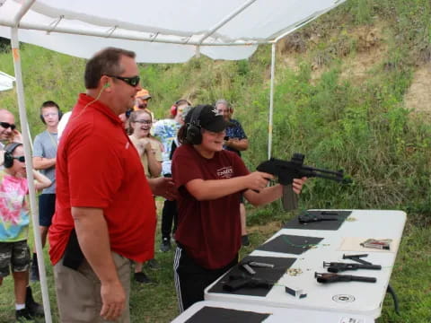 a man holding a gun and standing next to a man holding a gun