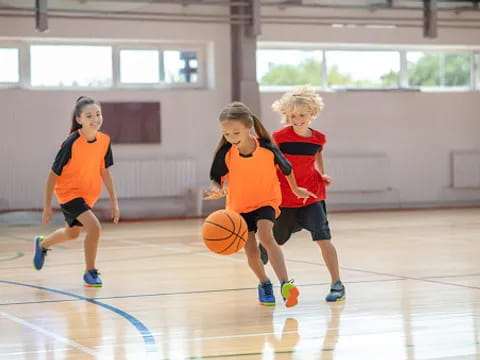 a group of kids playing basketball