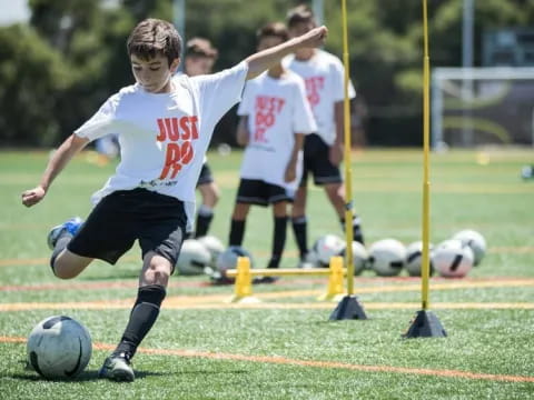 a boy kicking a football ball