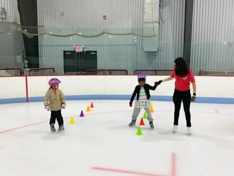 a person and two children on an ice rink