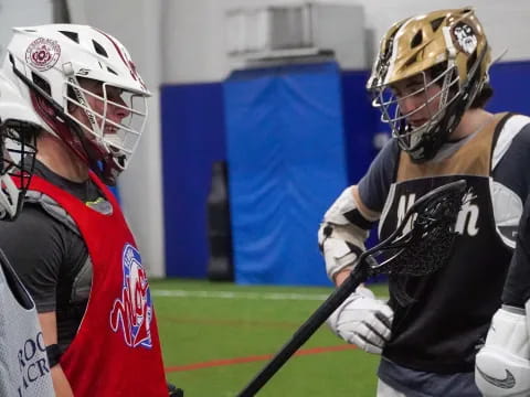 a couple of people playing lacrosse