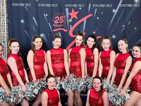 a group of women in red dresses