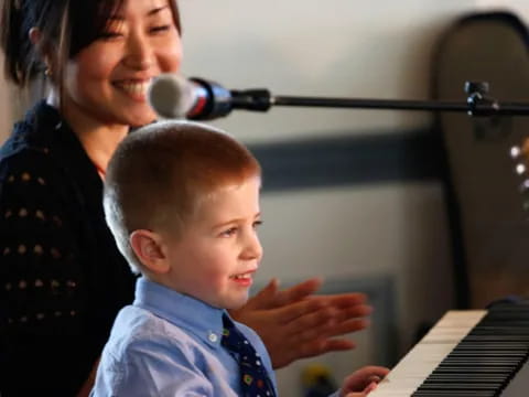 a person and a child playing piano