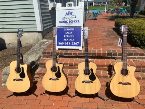 a group of guitars on a brick surface