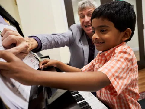 a person showing a boy something on the paper