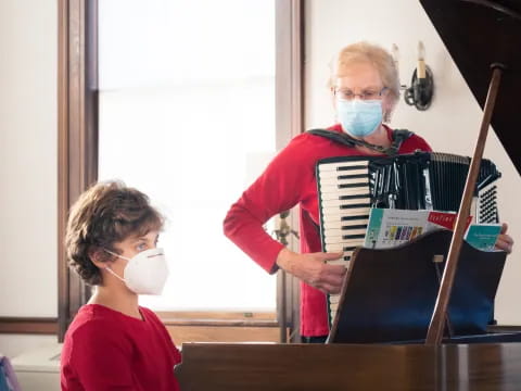 a person and a boy wearing face masks and holding musical instruments