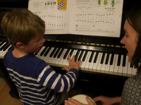 a person and a child playing a piano