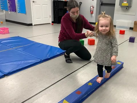 a person and a girl playing on a mat