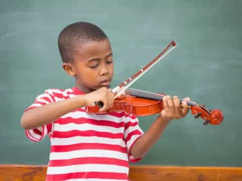 a young boy playing a violin