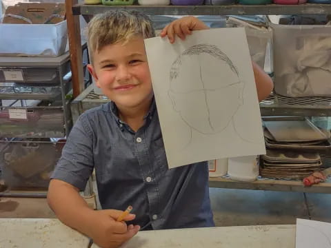 a boy holding a drawing