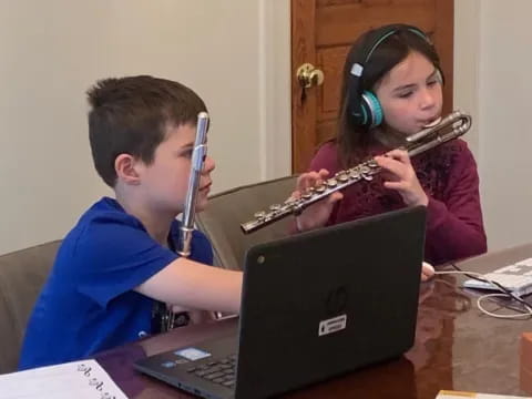 a boy and girl playing a flute