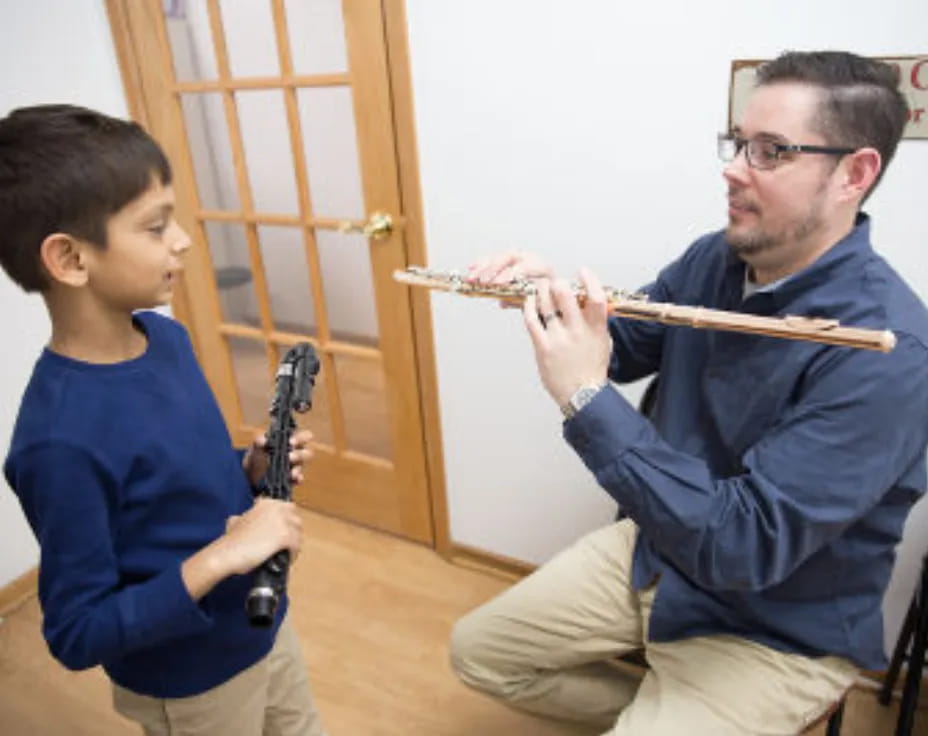 a person and a boy playing a flute