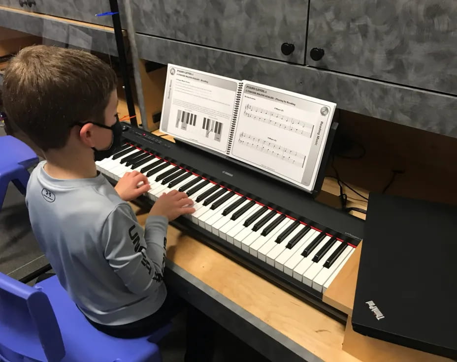 a boy playing a piano