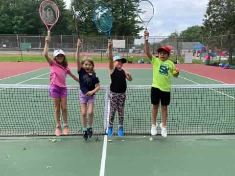 kids holding tennis rackets