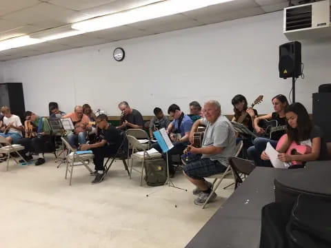 a group of people sitting in a room with instruments