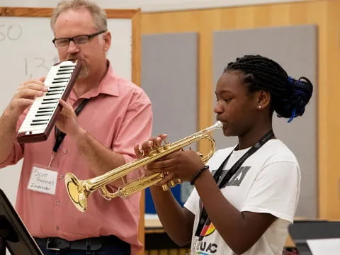 a man playing a trumpet next to a woman playing a musical instrument