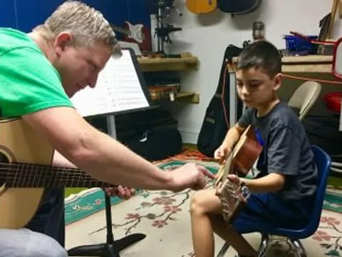 a person playing a saxophone with a young boy