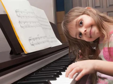 a girl sitting at a piano