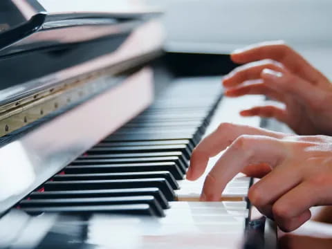 hands playing piano with a keyboard