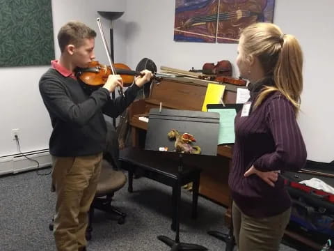 a boy and girl playing a violin