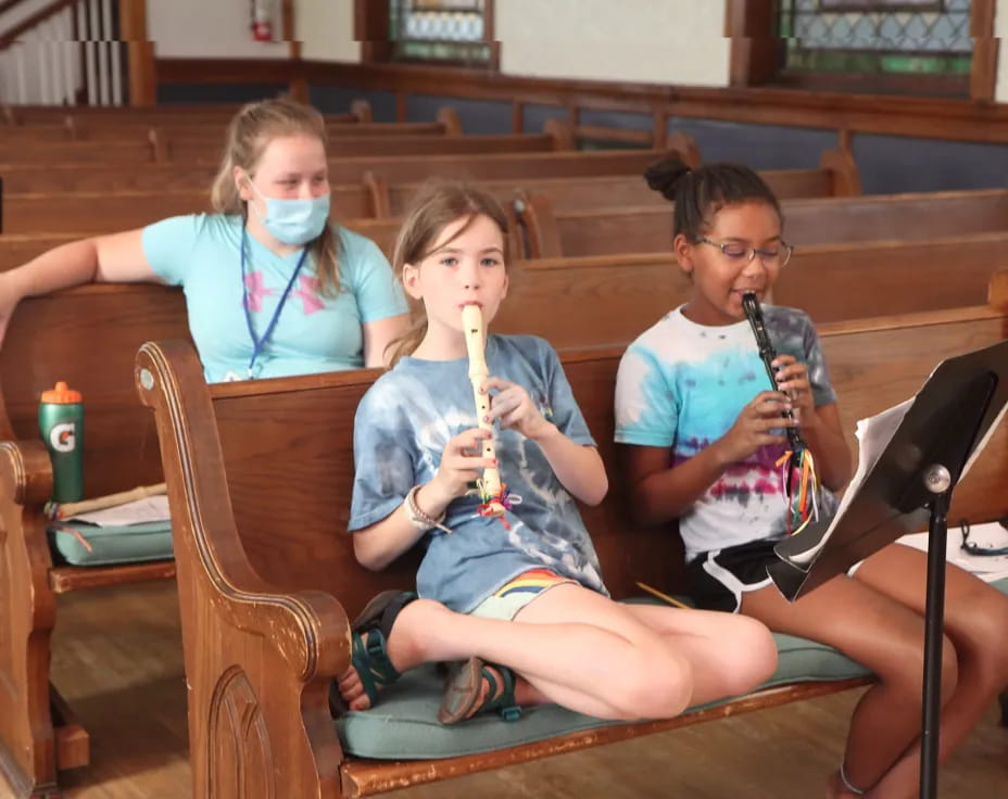 a group of kids sitting in chairs with musical instruments