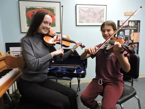 a couple of women playing violin