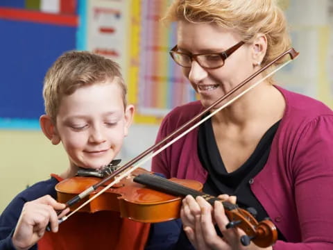 a person playing a violin next to a boy