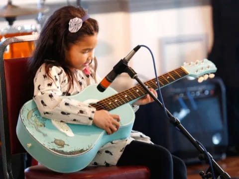 a girl playing a guitar