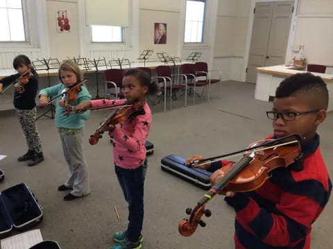 a person playing a violin with a group of children