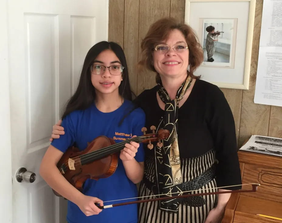 two women holding a guitar