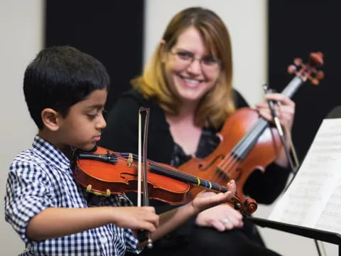 a person and a boy playing violin