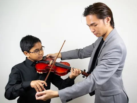a woman playing a violin next to a man playing a violin