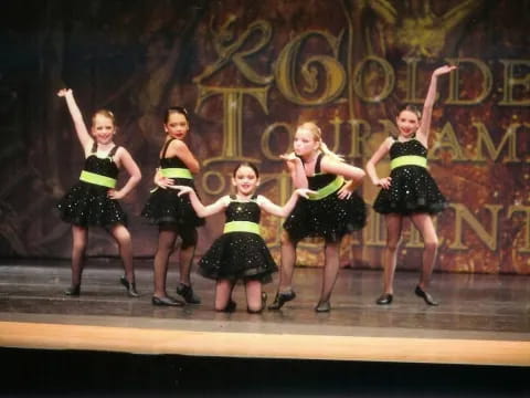 a group of girls in a dance pose on a stage