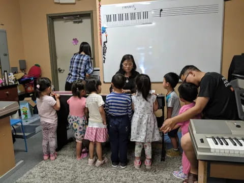 a group of people standing in a room with a whiteboard