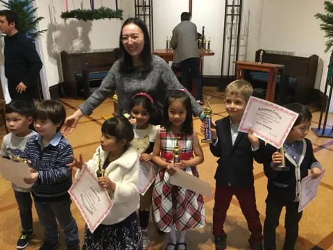 a person and a group of children holding papers