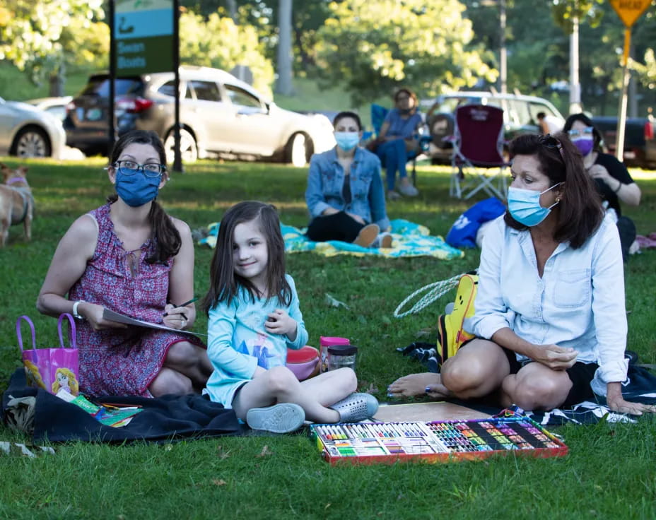 a group of people sitting on the grass