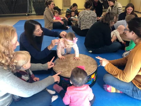 a group of people sitting on the floor with a baby