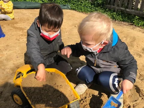 two boys playing in sand
