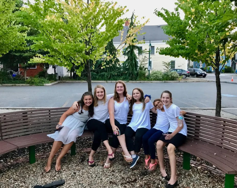 a group of women sitting on a bench