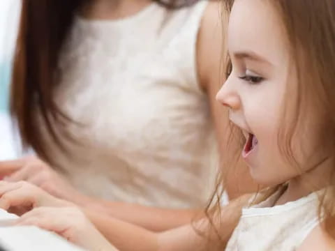 a woman and a child playing a piano