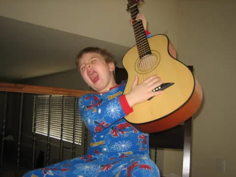 a boy holding a guitar