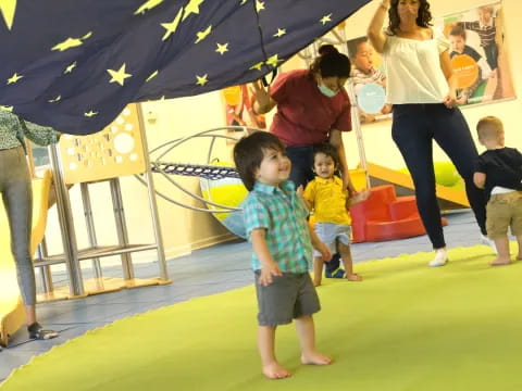 a group of people playing on a green and yellow trampoline