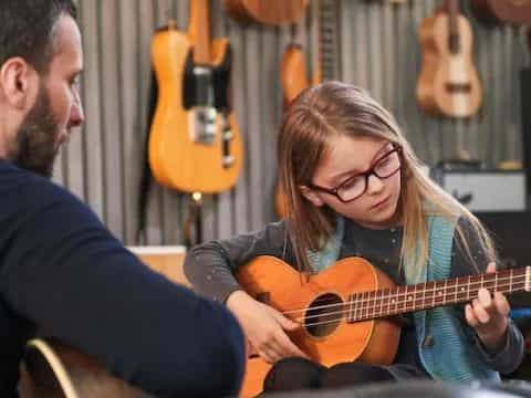 a man and a woman playing a guitar