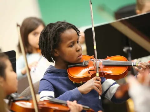 a young boy playing a violin