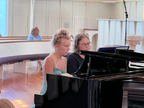 a couple of women playing piano